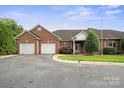 Charming brick home featuring an attached two-car garage, manicured lawn, and inviting entryway at 104 Mooreland Ne Dr, Conover, NC 28613