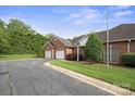Side view of a brick home with an attached two-car garage and well-kept lawn at 104 Mooreland Ne Dr, Conover, NC 28613