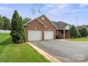 Attached two car garage featuring white doors and red brick facade at 104 Mooreland Ne Dr, Conover, NC 28613