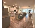 Open kitchen with granite counters, stainless appliances, and a large island with seating for three at 10417 Bluejack Oak Ct, Huntersville, NC 28078