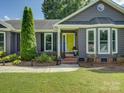 Home featuring a yellow front door, bay windows and meticulously landscaped yard at 116 Hallett St, Fort Mill, SC 29715