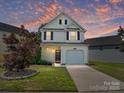 Charming two-story home with a well-maintained lawn, driveway, and attached garage, situated under a colorful twilight sky at 12131 Honor Guard Ave, Charlotte, NC 28277
