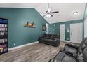 Comfortable living room boasts sleek flooring, vaulted ceiling, and relaxing black leather furniture at 124 Turning Leaf Ln, Statesville, NC 28677