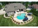 Aerial view of a backyard oasis with a luxurious pool, spa, and outdoor entertaining area at 141 Castle Dr, Mooresville, NC 28117