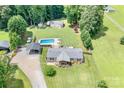 Aerial view of property showing in-ground pool, shed, carport and lovely home with landscaped front porch at 1489 L R Schronce Ln, Iron Station, NC 28080