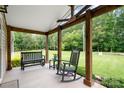Cozy covered porch featuring a rocking chair, bench seating, and decorative plants, offering a relaxing outdoor space at 1489 L R Schronce Ln, Iron Station, NC 28080