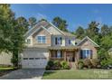 Two-story home featuring stone accents, a covered porch, a two car garage, and lush lawn at 17537 Caddy Ct, Charlotte, NC 28278
