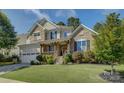Beautiful two-story home featuring stone accents, an inviting front porch, and lush landscaping at 17537 Caddy Ct, Charlotte, NC 28278