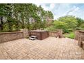 Relaxing backyard patio features a hot tub, stone privacy walls and beautiful pavers for an amazing outdoor experience at 2019 Heirloom Ct, Matthews, NC 28104