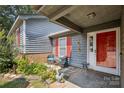 Welcoming front porch with sitting area, red door, and vibrant flower garden at 432 English Ivy Ct, Fort Mill, SC 29715