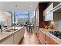 Stylish kitchen with stainless appliances and a grand piano within view, bathed in natural light at 435 S Tryon St # 907, Charlotte, NC 28202