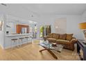 Bright living room featuring hardwood floors, white walls, and an open layout with kitchen view at 498 Glory Ct, Fort Mill, SC 29715