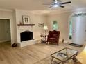 Inviting living room features a fireplace with white-painted brick, modern lighting, and wood flooring at 7408 Mockingbird Ln, Waxhaw, NC 28173