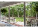 Covered front porch offering a serene view of the lush backyard, creating a relaxing outdoor space at 7408 Mockingbird Ln, Waxhaw, NC 28173