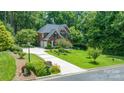 Elevated view of a well-maintained brick home with an attached two-car garage, lush lawns, and a private, wooded lot at 1069 Westlake Dr, Kannapolis, NC 28081