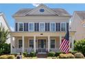 Inviting two-story home with a classic front porch and an American flag displayed proudly at 11806 Stirling Field Dr, Pineville, NC 28134
