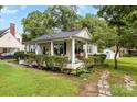 Inviting home with a spacious front yard, mature trees, and a charming porch, perfect for enjoying the outdoors at 1210 Jackson Rd, Gastonia, NC 28052