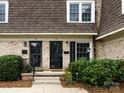Exterior view showcasing brick facade, black front doors, and well-maintained landscaping at 1708 Roxborough Rd # C, Charlotte, NC 28211