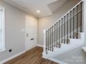 Inviting foyer featuring a staircase with black railings and wood-look flooring at 1708 Roxborough Rd # C, Charlotte, NC 28211