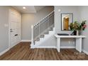 Bright foyer featuring sleek console table, staircase with black railings and wood-look floors at 1708 Roxborough Rd # C, Charlotte, NC 28211
