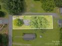 Aerial view of a property showing the house, surrounding land, and nearby trees at 201 Oakland Dr, Lowell, NC 28098
