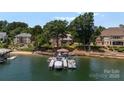 Lakefront home with a private dock, boat slips, and lush green surroundings at 3996 Channel Point Ln, Denver, NC 28037