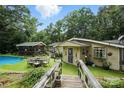 A lovely, elevated backyard view with a pool, dining set, and a wooden bridge to an expansive property at 4412 Dobys Bridge Rd, Fort Mill, SC 29707
