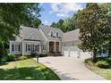 Charming home with a three-car garage, stone accents, and a basketball hoop on a well-manicured lawn at 4536 Rustling Woods Dr, Denver, NC 28037