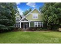 Inviting two-story green home with well-maintained landscaping and a stone-clad front porch at 458 Leaf Arbor Ct, Clover, SC 29710