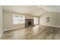Bright living room with wood floors, a stone fireplace, vaulted ceilings and sliding glass doors to the backyard at 4937 Post Oak Ln, Rock Hill, SC 29732