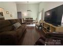 Cozy living room featuring hardwood floors, comfortable seating, and open access to dining area at 6007 Crosswood Ct, Charlotte, NC 28215