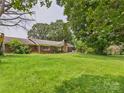 Brick ranch home surrounded by mature trees on a sprawling green lawn at 61 23Rd Nw St, Hickory, NC 28601