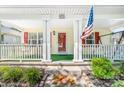 Close up view of a cozy front porch featuring a cheerful welcome mat and an American flag at 611 Church St, Belmont, NC 28012