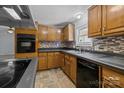 Functional kitchen with dark countertops, mosaic backsplash, wooden cabinets and an oven at 7011 S Providence Rd, Waxhaw, NC 28173