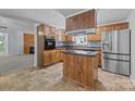 Kitchen with wooden cabinets, stainless steel appliances, island and view of the living room at 7011 S Providence Rd, Waxhaw, NC 28173