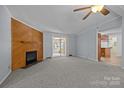 Cozy living room with a wood-paneled fireplace, neutral carpet and adjacent sunroom at 7011 S Providence Rd, Waxhaw, NC 28173
