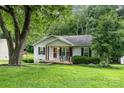 View of home with covered front porch and well maintained yard, surrounded by lush greenery at 704 Willow Rd, Salisbury, NC 28147