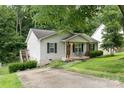 Cozy home with a covered front porch, dark shutters and a driveway leading to a lower level at 704 Willow Rd, Salisbury, NC 28147