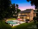 Inviting backyard oasis featuring a swimming pool, covered patio, and ample green space at 7229 Olde Sycamore Dr, Mint Hill, NC 28227