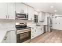 Modern kitchen featuring white cabinets, stainless steel appliances, and a stylish subway tile backsplash at 9410 Mountain Aire Cir, Charlotte, NC 28214