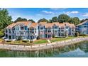 View of blue townhome showcasing a waterfront with well-manicured landscaping at 1007 Southwest Dr, Davidson, NC 28036