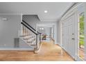 Inviting foyer with hardwood floors, staircase, and view into dining area at 10918 Megwood Dr, Charlotte, NC 28277