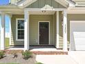 Inviting front entry showcasing a classic front door, brick accents, and manicured landscaping at 11507 Valley Oak Ln, Stanfield, NC 28163