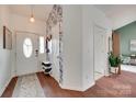 Bright entryway with decorative wallpaper, shoe storage, and a leaded glass front door at 11615 Chadburn Ln, Charlotte, NC 28215