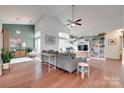 Open living room with vaulted ceilings, hardwood floors, large windows, and built-in bookshelves at 11615 Chadburn Ln, Charlotte, NC 28215
