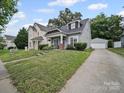 Charming home with a detached garage, lush green lawn and mature trees at 1228 Rising Oak Dr, Charlotte, NC 28206