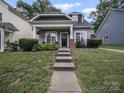 Charming home featuring manicured lawn and welcoming front porch with inviting chairs at 1228 Rising Oak Dr, Charlotte, NC 28206