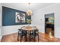 This bright dining room features hardwood floors, a unique light fixture, and decorative wall art at 13010 Indian Hills Ln, Charlotte, NC 28278