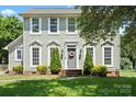 Charming two-story home with a well-manicured lawn, decorative shrubs, and a welcoming front entrance at 13010 Indian Hills Ln, Charlotte, NC 28278