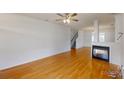 Spacious living room with hardwood floors, fireplace, and staircase at 15280 Leslie Brook Rd, Huntersville, NC 28078